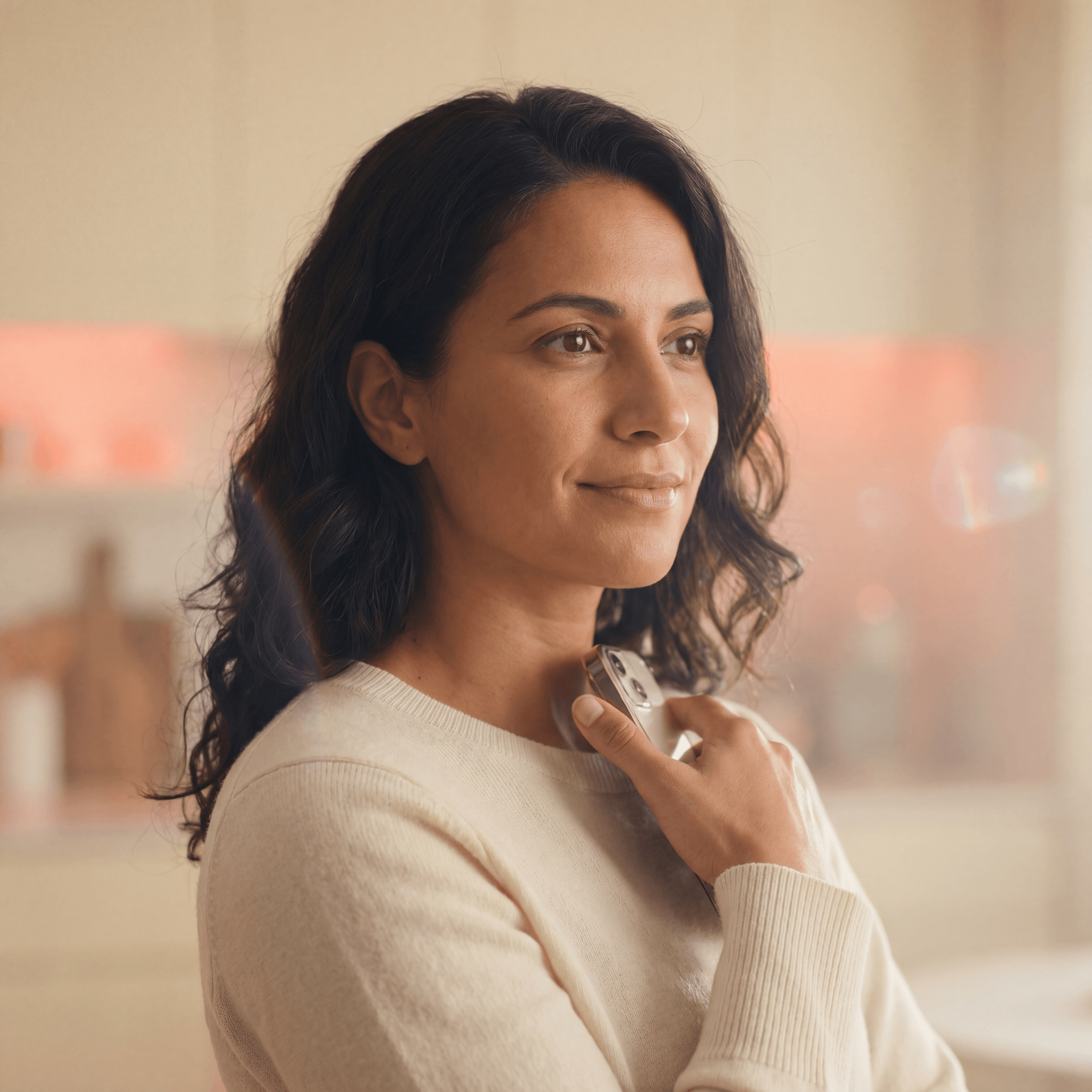 Cliente BlueLock — brasileira segurando smartphone com app aberto, ambiente caseiro com acento coral